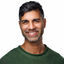 Khurram Naik smiling in a green sweater